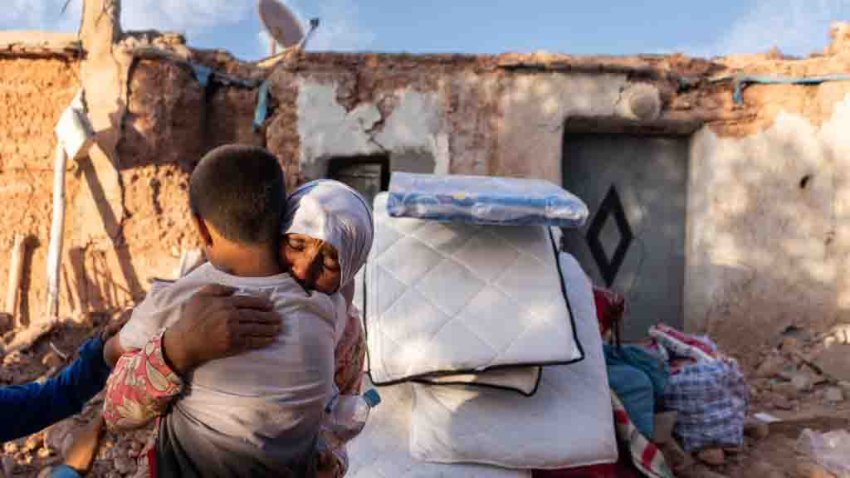 A woman comforts a child outside a destroyed house following an earthquake in Tafeghaghte, in the Al Haouz region of Morocco, on Sunday, Sept. 10, 2023. The catastrophe deals a stunning blow to the country of 37 million that views itself an island of stability in North Africa and which has been a bright spot for investors wary of the region’s other economies. Photographer: Nathan Laine/Bloomberg via Getty Images