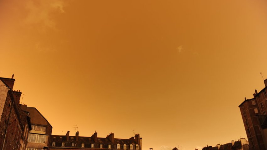 TOPSHOT – A picture taken on October 16, 2017, in central Rennes, western France, shows rooftops and the sky after it turned a yellow-ochre colour due to sand from the Sahara desert and dust from wildfires in Portugal being carried by wind from the Storm Ophelia. / AFP PHOTO / Marie DUFAY        (Photo credit should read MARIE DUFAY/AFP via Getty Images)